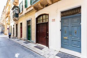 a building with blue doors on the side of a street at Valletta Archbishop 2 in Valletta