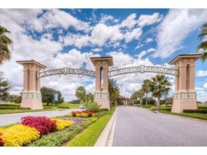 a large arch over a road with flowers at Luxury Champions Gate Condo-Disney Firework Views! in Kissimmee