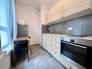 a kitchen with a stove and a table and a sink at K22 Komputerowa Warsaw Apartments in Warsaw