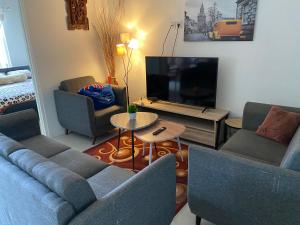 sala de estar con sofá y TV en Villa Penny II, en Batu