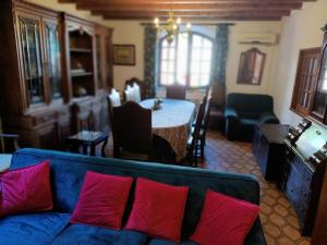 sala de estar con sofá azul y almohadas rojas en Casa Piscina Aquecida para 10 adultos Zona Sintra, junto praia, en Colares