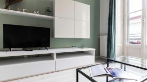 a living room with a tv on a white entertainment center at Liberty Home in Sesto San Giovanni