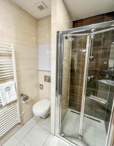 uma casa de banho com um WC e uma cabina de duche em vidro. em Hotelový apartmán ALFRED C407 em Starý Smokovec