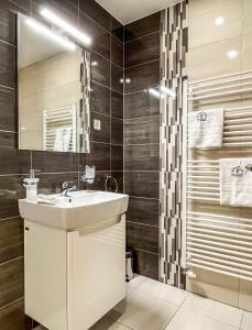 a bathroom with a sink and a shower at Hotelový apartmán ALFRED C407 in Smokovce