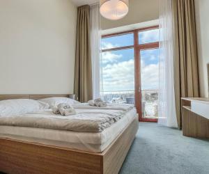 a bedroom with a bed and a large window at Hotelový apartmán ALFRED C407 in Smokovce +20 photos
