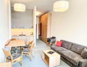 a living room with a couch and a table at Hotelový apartmán ALFRED C407 in Smokovce