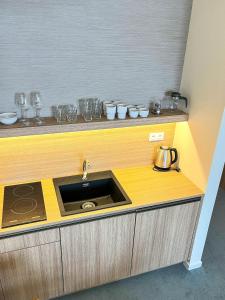 a kitchen counter with a sink and some glasses at Hotelový apartmán ALFRED C407 in Vysoke Tatry - Stary Smokovec