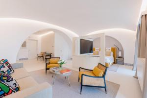a living room with a couch and a tv in a room at Palazzo M Capri in Capri