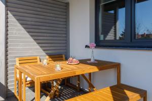 a wooden table and chairs on a patio at Seaside Escape Pet Friendly Apartments Mielenko by Renters in Mielenko