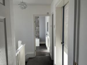 a hallway with white walls and a hallway with a hallway at M1Link 3 bed house up to 7 people free parking, wifi, M1, transport links, enclosed L garden in Sutton in Ashfield
