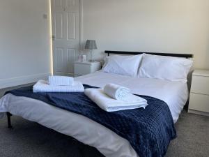 1 dormitorio con 1 cama con toallas en M1Link 3 bed house up to 7 people free parking, wifi, M1, transport links, enclosed L garden, en Sutton-in-Ashfield
