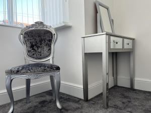 a chair next to a desk and a mirror at M1Link 3 bed house up to 7 people free parking, wifi, M1, transport links, enclosed L garden in Sutton in Ashfield