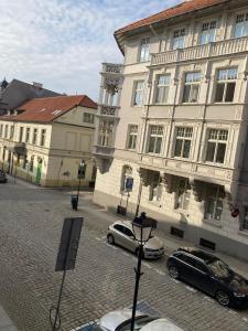 dwa samochody zaparkowane przed dużym budynkiem w obiekcie Szymborska Apartamenty Mostowa 18-2 w Toruniu +2 zdjęcia