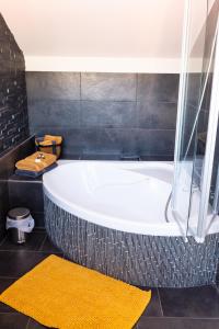 a bath tub in a bathroom with a yellow rug at Baumeister`s Ferienwohnung in Niederlauer