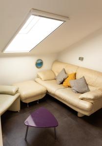 a living room with a couch and a skylight at Baumeister`s Ferienwohnung 