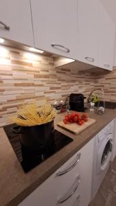 a kitchen counter with a pot of spaghetti and tomatoes on a cutting board at La casetta in Cuneo