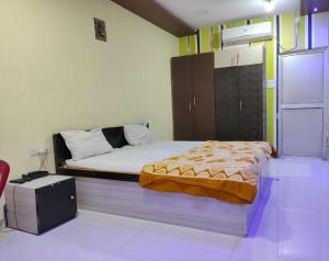 STAYMAKER Madhuwan Heights في Bokāro: غرفة نوم فيها سرير وكابينة