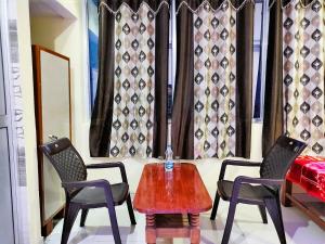 STAYMAKER Madhuwan Heights في Bokāro: غرفة بها كرسيين وطاولة و كرسيين