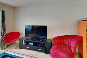 sala de estar con silla roja y TV en Sunset Harbor 2-204 - Latitude Adjustment, en Navarre
