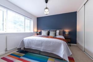 Deepdene Close في ريدينغ: غرفة نوم بسرير وجدار ازرق