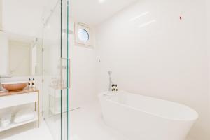 un bagno bianco con doccia e porta in vetro di Palazzo M Capri a Capri