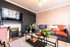 a living room with a couch and a fireplace at Deepdene Close in Reading