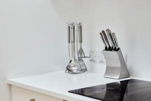 a kitchen counter with knives and utensils on it at Swanky city centre apartment in Lincolnshire