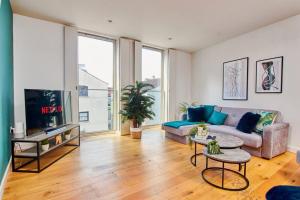 a living room with a couch and a tv at Swanky city centre apartment in Lincolnshire