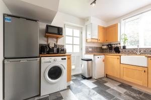 a kitchen with a washer and dryer in it at Deepdene Close in Reading