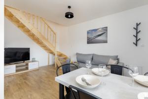 a living room with a table with chairs and a tv at Seaside Escape Mielenko by Noclegi Renters in Mielenko