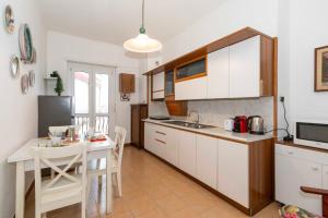 eine Küche mit weißen Schränken und einem Tisch sowie eine Küche mit einem Esszimmer in der Unterkunft Tesoriera Comfy Apartment in Turin in Turin
