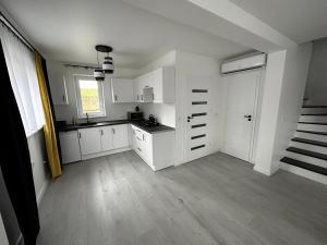 an empty kitchen with white cabinets and a staircase at Agroturystyka Parcele 