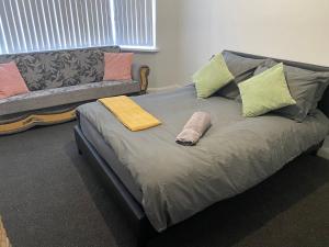 a bed with pillows and a couch in a room at Coventry Spacious House in Coventry