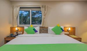 a bedroom with a large bed with a window at Treebo Trend Gyani's in Jamshedpur