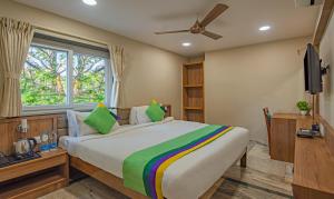 a bedroom with a large bed and a window at Treebo Gyani's in Jamshedpur