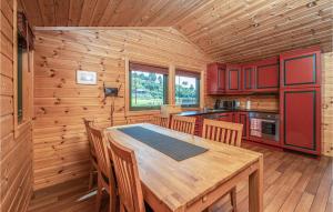 una cocina con mesa de madera y sillas en una cabaña en Beach Front Home In ydegard With House A Panoramic View, 