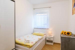a small bedroom with a bed and a window at Apartments Mirela in Koper