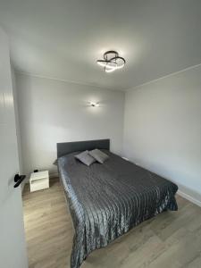 een slaapkamer met een bed in een witte kamer bij Apartamenty Rodzina nad morzem in Gdańsk