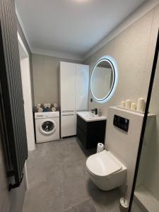W łazience znajduje się toaleta, umywalka i pralka. w obiekcie Apartamenty Rodzina nad morzem w Gdańsku