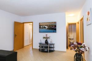 a living room with a vase of flowers on a table at Apartments Mirela in Koper