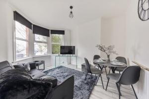 - un salon avec un canapé et une table dans l'établissement Beautifully Modern 2-Bed Apartment w/garden, à Londres