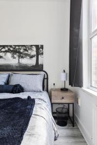 - une chambre avec un lit, une table et une fenêtre dans l'établissement Beautifully Modern 2-Bed Apartment w/garden, à Londres