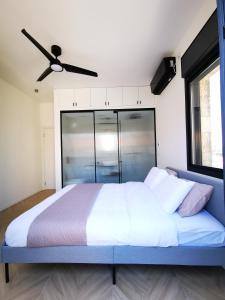 a bedroom with a large bed with a ceiling fan at The Beauty Queen of Jerusalem in Jerusalem