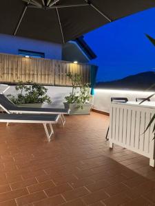 a patio with a bench and an umbrella at Bakke Design Loft in Sestri Levante