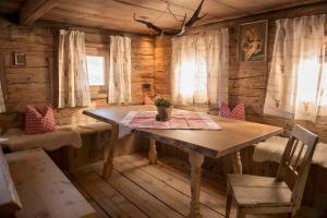 - une salle à manger avec une table dans une cabane en rondins dans l'établissement Wildauhof - Alm, à Fügenberg