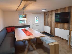 a living room with a wooden table and a couch at Wildauhof - Bauernhaus in Fügenberg