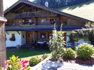 a wooden house with flowers in the front yard at Wildauhof - Bauernhaus in Fügenberg