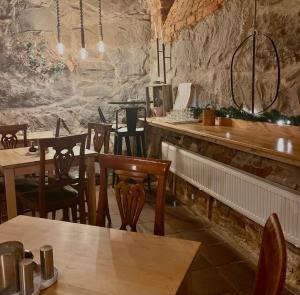 a restaurant with tables and chairs and a stone wall at Lilla Brunn in Stockholm