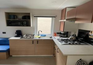 a small kitchen with a sink and a stove at Détente-famille-lac in Biscarrosse