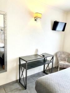 a desk in a room with a bed and a mirror at Hotel Lou Marquès in Saintes-Maries-de-la-Mer